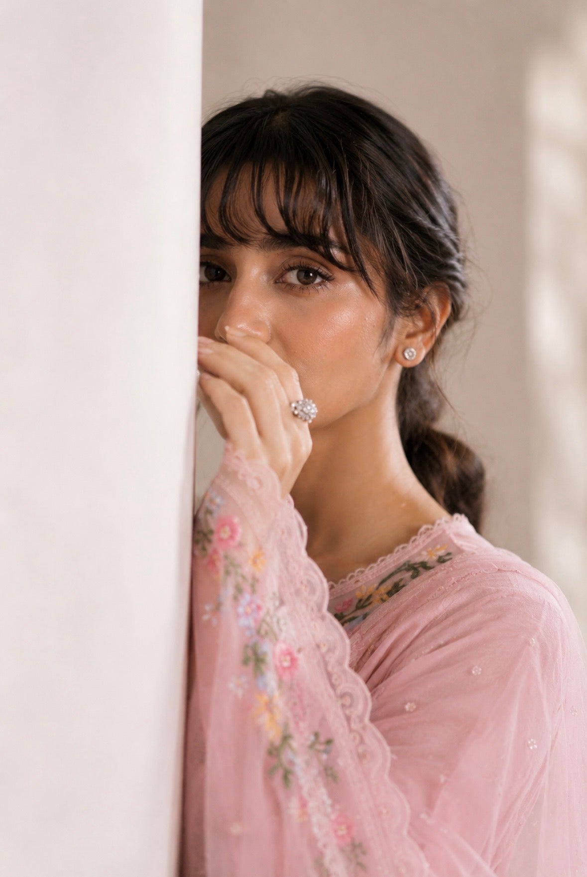 Woman wearing a pink floral dress with a blurred background