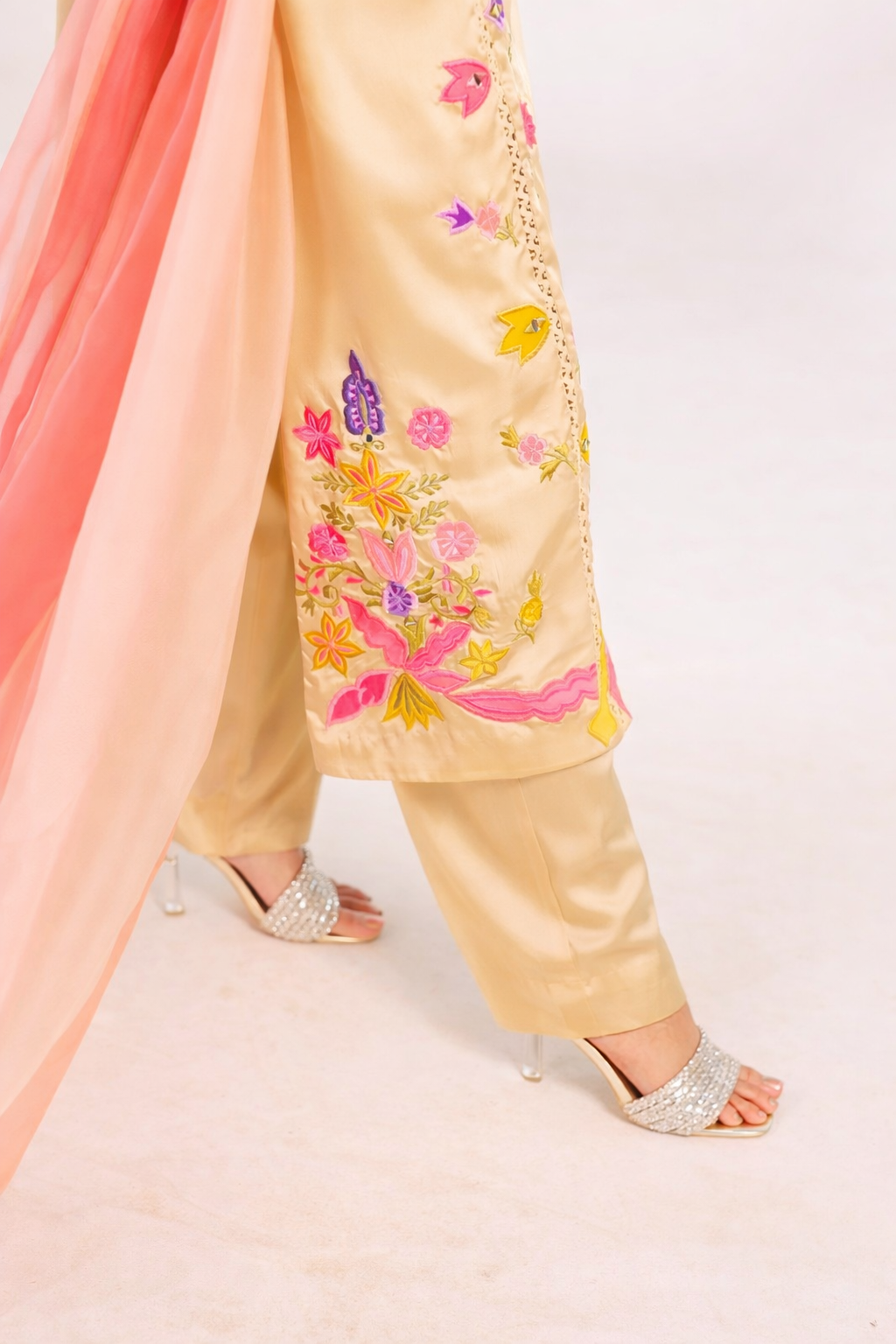 Beige embroidered outfit with pink dupatta on a white background