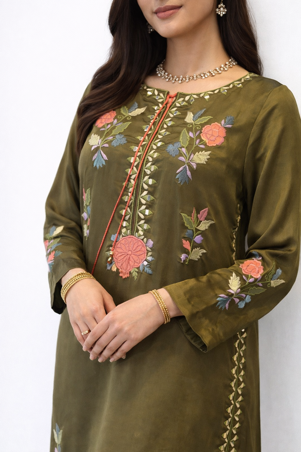 Olive raw silk long Close-up of Olive Enigma dress in raw silk with multi-color floral appliqué and embroidery, handcrafted in Pakistan for Eid 2026. urta kaftan 