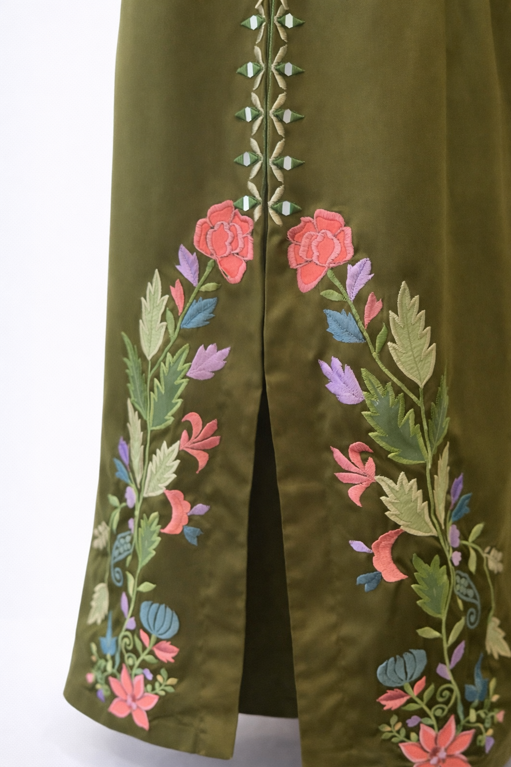Green embroidered garment with floral patterns on a white background