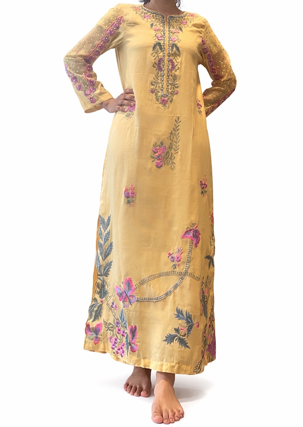 Woman wearing Yellow embroidered Pakistani Indian formal ready to wear dress on a white background. 