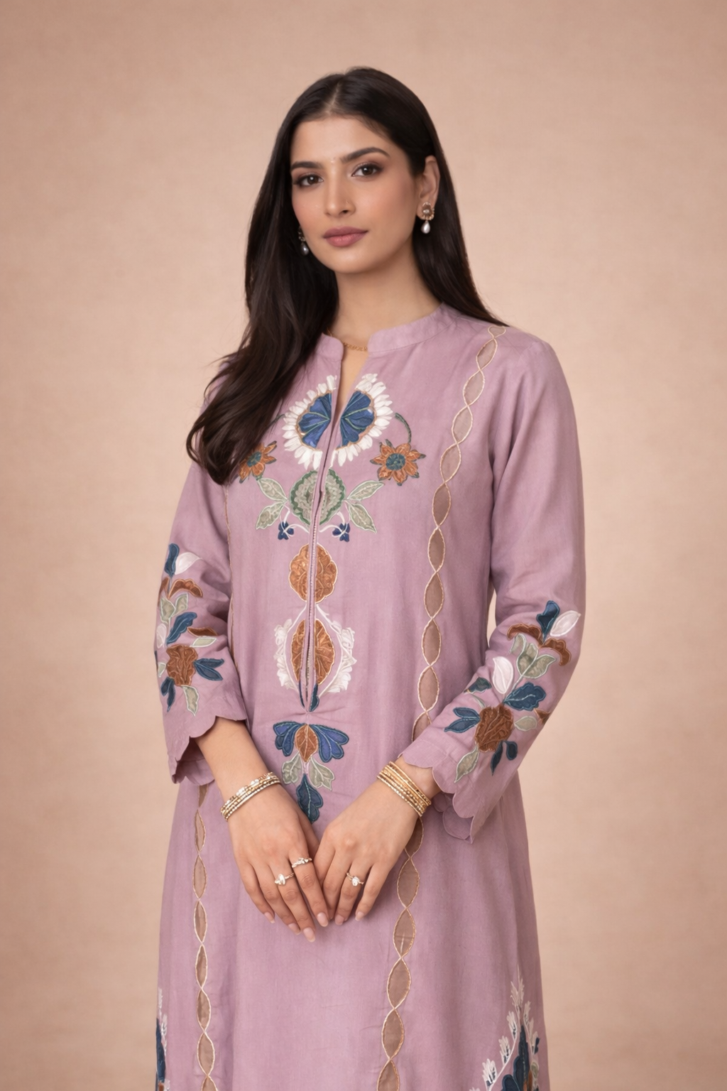 Woman wearing a light purple embroidered kaftan dress against a beige background