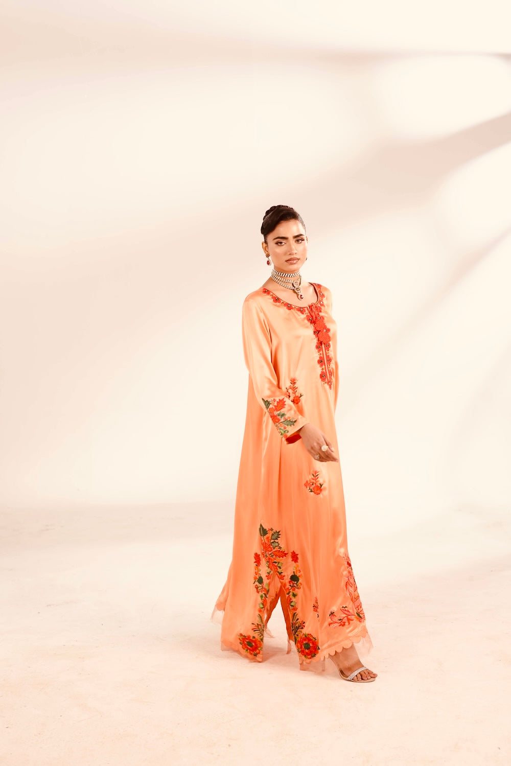 Woman wearing a peach floral outfit on a white background